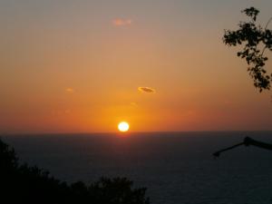 um pôr-do-sol sobre o oceano com o sol no céu em Sweetposeidon em Ischia