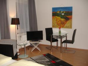 ein Wohnzimmer mit einem Tisch und einem TV in der Unterkunft City-Pension-Dortmund in Dortmund