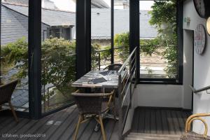 a porch with a table and chairs on a balcony at Hôtel Restaurant Corto Maltese in Le Palais