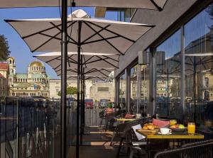 un patio con tavoli e ombrelloni su un balcone di InterContinental Sofia, an IHG Hotel a Sofia