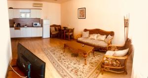 a living room with a couch and a kitchen at Oasis Suites Apartments and Studios in Ravda