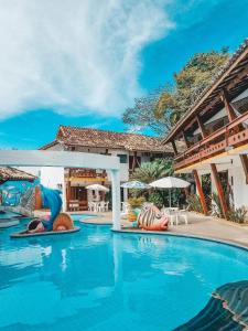 una piscina en un complejo con personas sobre inflables en Casa Blanca Park Hotel en Porto Seguro