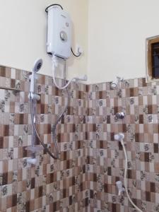 a shower in a bathroom with a shower head at BAS Balcony in Anuradhapura