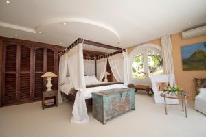a bedroom with a canopy bed and a table at Four Uitsig Camps Bay in Cape Town