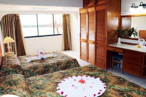 a hotel room with two beds and a desk at Crown Point Beach Hotel in Crown Point