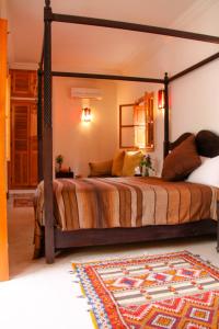 a bedroom with a canopy bed with a rug at Riad Mariana in Marrakesh