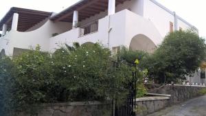 una casa bianca con una recinzione e alberi di Casa Engy a Città di Lipari