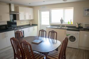kuchnia ze stołem, krzesłami i zlewem w obiekcie The Lawns Guest House w mieście Retford
