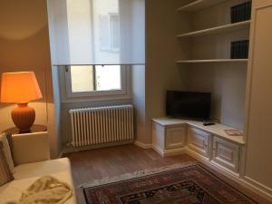 a living room with a tv and a bed and a lamp at La Casa di Paola in Lovere