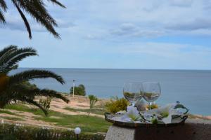オリフエラ・コスタにあるEl Apartamento De Papá - Mil Palmerasのビーチの近くのテーブルに座ったワイングラス2杯