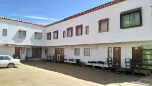 a white building with a car parked in front of it at Costa Margarita in El Tabo