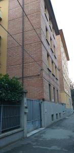 a tall brick building with a gate in front of it at House Procaccini, 20 in Bologna
