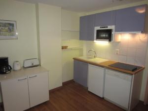 エクスレバンにあるAstay Residence 31の白いキャビネット、シンク、電子レンジ付きのキッチンが備わります。