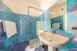 a bathroom with a sink, toilet, and bathtub at Hotel Luna Lughente in Olbia
