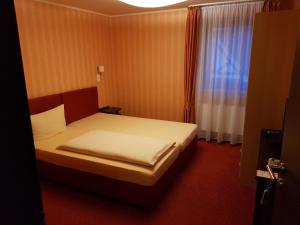 a bedroom with a bed and a window at Hotel Haupt in Kobern-Gondorf