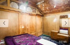 una piccola stanza con un letto e uno specchio di S Group Of Houseboat a Srinagar