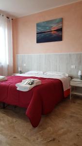 a bedroom with a large bed with a red blanket at Happy House in Coppito