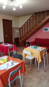 a room with tables and chairs and a staircase at Happy House in Coppito