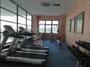 a gym with cardio equipment and a brick wall at Rumah Cik Ani in Shah Alam