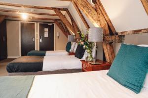 ein Hotelzimmer mit zwei Betten und einer Lampe in der Unterkunft Hotel Corner House in Amsterdam