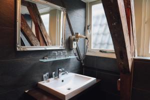 bagno con lavandino e 2 specchi di Hotel Corner House ad Amsterdam