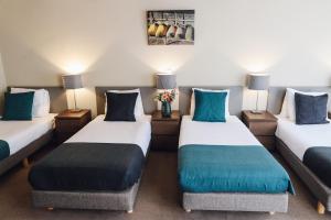 een kamer met 2 bedden en blauwe kussens bij Hotel Corner House in Amsterdam
