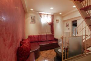 uma sala de estar com um sofá vermelho e uma escada em il casseretto em Ascoli Piceno