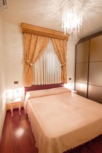 Un dormitorio con una cama grande y una lámpara de araña. en il casseretto, en Ascoli Piceno