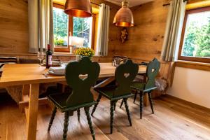a dining room with a wooden table and chairs at Schneehaus Lodge in Ehrwald