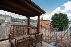 Un balcón con 2 sillas de madera y una mesa. en il casseretto, en Ascoli Piceno