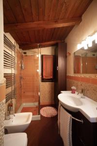 uma casa de banho com 2 lavatórios e um chuveiro em il casseretto em Ascoli Piceno