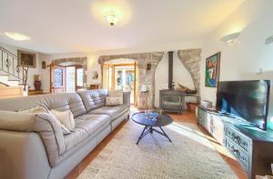 uma sala de estar com um sofá e uma televisão de ecrã plano em Holiday Home Lavanda em Kornic