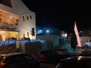 a lit up christmas tree next to a building at Villa Nazareth B&B in Nazareth