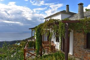 a cottage with a table and chairs on a balcony at Esperos Suites & Villas in Lafkos