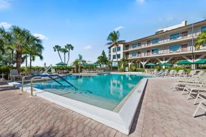 una piscina con sillas y un hotel en Caribbean Beach Club en Fort Myers Beach