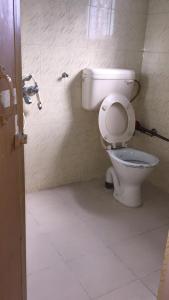 a bathroom with a white toilet in a stall at Vamoose Cosynook Homestay in Takdāh