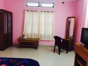 a living room with pink walls and a table and a mirror at Vamoose Cosynook Homestay in Takdāh