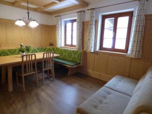 jadalnia ze stołem, krzesłami i oknami w obiekcie Ferienhaus Veider w mieście Obertilliach