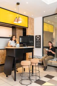 two women sitting at a counter in a restaurant at Aparthotel Adagio Access Paris Vanves - Porte de Versailles in Vanves