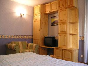 a bedroom with a bed and a cabinet with a tv at Odesos Apartments in Varna City