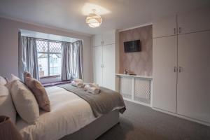 a bedroom with a large bed with a window at Goldcrest House by RentMyHouse in Hereford