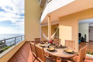 una sala da pranzo con tavolo e sedie su un balcone di Apartamento Serramar , Vistas deslumbrantes a Calheta