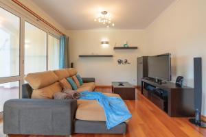 un soggiorno con un divano e una TV di Apartamento Serramar , Vistas deslumbrantes a Calheta