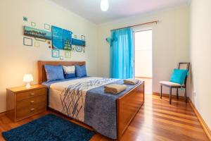 una camera da letto con un letto e una sedia di Apartamento Serramar , Vistas deslumbrantes a Calheta Altre 38 foto