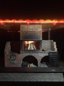 a brick fireplace with a fire in it at night at Cabana 7 Brazi in Poiana Mărului