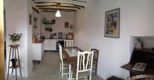 - une cuisine et une salle à manger avec une table et des chaises dans l'établissement Casa De Juanita Vivienda Rural, à Hinojares
