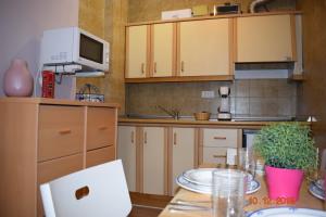 a kitchen with wooden cabinets and a table with plates on it at SUEÑO NEVADO MONT BLANC plaza PRADOLLANO in Sierra Nevada