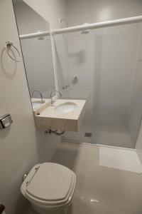 uma casa de banho branca com um WC e um lavatório em Ipê Hotel Express em Ponta Grossa