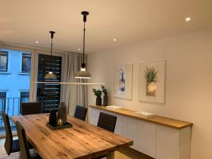 cocina y comedor con mesa de madera en The Apartment Downtown, en Mainz