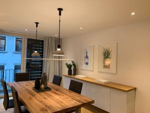 a kitchen and dining room with a wooden table at The Apartment Downtown in Mainz